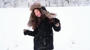 Mutlu kız kış soğuğunda dışarıda karla oynuyor, kış tatillerinde.