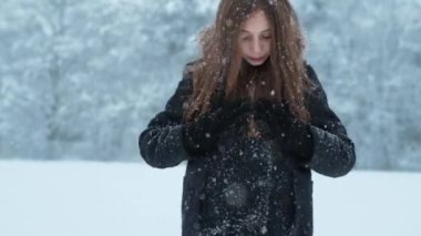 Mutlu kız kış soğuğunda dışarıda karla oynuyor, kış tatillerinde.