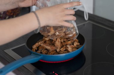 Eti tavada karıştıran bir kadın.,