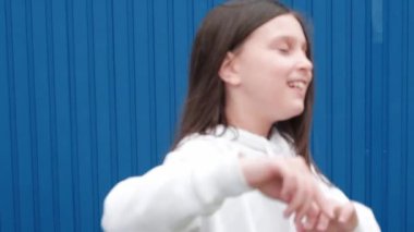 Mavi arka planda dans eden tatlı kız. 