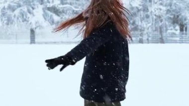 Küçük tatlı kız soğuk kış havasında karla eğleniyor. Kış mevsimi neşesi