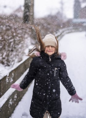  Neşeli bir genç kız kış harikalar diyarında oynuyor.