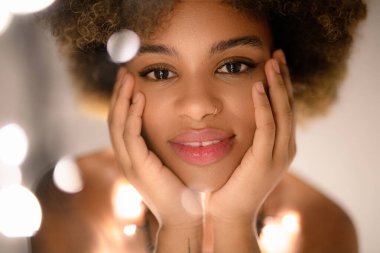 Beautiful african woman holding christmas garland clipart