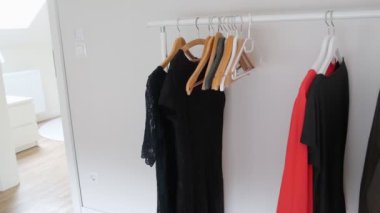 Taşınabilir bir askıda kadın gardırobu. Kadın elbiseleri. Beyaz arkaplan