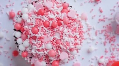 Valentine's Day. Cake decorated with hearts and sprinkles on a white background.