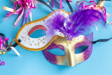 Festive face mask for carnival celebration on blue background. Mardi gras carnival background with carnival masks. 