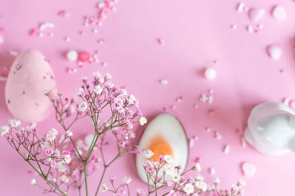 Easter background with colored Easter eggs and blooming flowers on a pink background. easter copy space