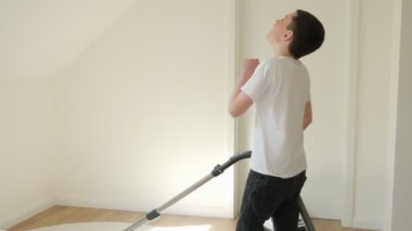 the boy cleans the vacuum cleaner and sings