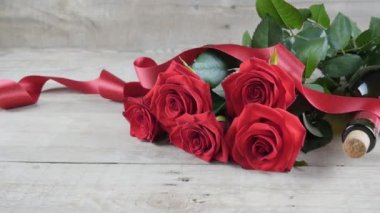 Valentines Day. Valentine background. Red roses and a bottle of wine on a wooden background