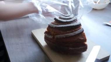 Ev yapımı ekmek kadın kesme tahtasına taze ekmek kesiyor. Taze sağlıklı ekmek.