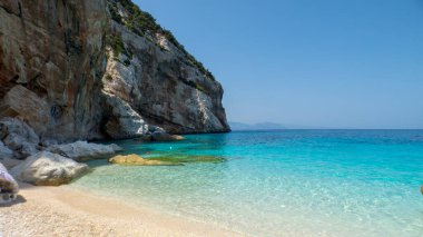 Cala Mariolu - Brunei - Nuoro - Sardinia - İtalya - Pembe Granitin Rocky kıyısı, kum ve küçük çakıl taşı plajı kristal berrak su denizine doğru yavaşça ilerliyor
