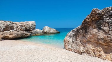 Cala Mariolu - Baunei - Nuoro - Sardinia İtalya - Pembe Granit 'in Rocky kıyısı, kum ve küçük çakıl taşı plajı kristal berrak su denizine doğru yavaşça ilerliyor