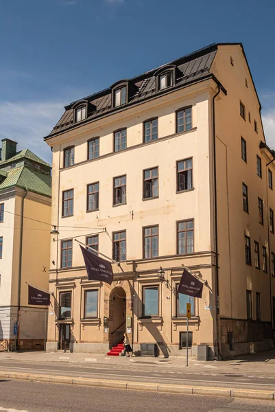 スウェーデン ストックホルム 2022年7月17日 ホテル ガムラ スタンの閉鎖Skeppsbron Quayの黄色の古典的な建物 青い空の下で正面 赤いカーペット 歩行者の名前を持つ茶色の旗 — ストック写真