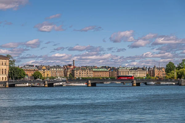 スウェーデン ストックホルム 2022年7月17日 Skeppsbron Quayから見られる赤いCuxlinerバスとSkeppholmsbron橋 青い雲と背後の街並みの下で — ストック写真