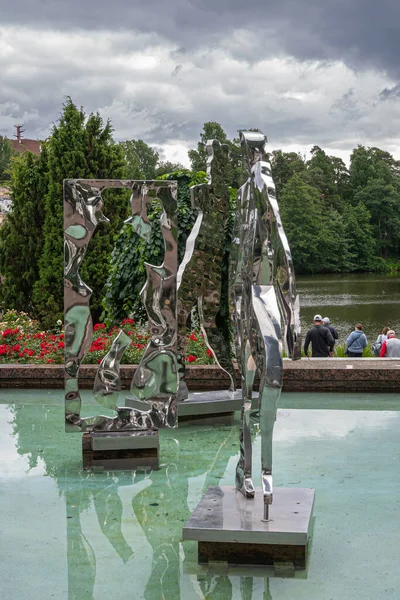 芬兰Kotka 2022年7月18日 Sopokanlahti公园和湖泊 绿色水池中的现代金属切割艺术雕像 灰色云彩下的绿化带 红花增色 — 图库照片