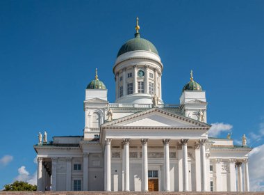 Helsinki, Finlandiya - 19 Temmuz 2022: Kubbe ve heykellerin yer aldığı mavi gökyüzüne karşı beyaz katedralin kapatılması