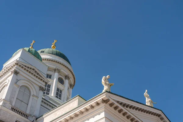 芬兰赫尔辛基 2022年7月19日 白色石头主教座堂的东北角落 蓝天装饰着两个绿色圆顶 上面有金色的尖顶和两个使徒雕像 菲利普手持打开的书本 — 图库照片