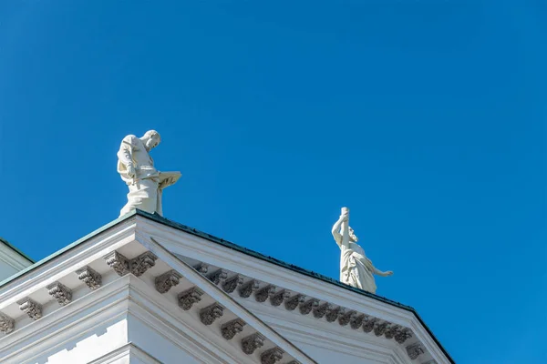 芬兰赫尔辛基 2022年7月19日 北面的石灰 两尊白色使徒雕像映衬蓝天 菲利普在看书 — 图库照片
