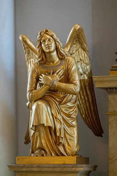 stock image Helsinki, Finland - July 19, 2022: Closeup of Kneeled golden angel statue on side of main altar in Cathedral.