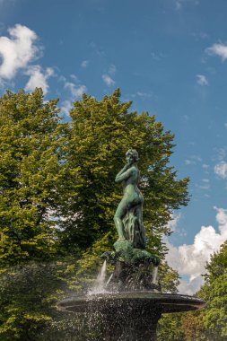 Helsinki, Finlandiya - 19 Temmuz 2022: Havis Amanda heykeli çeşmede ve Kaartinkaupunki Pazar Meydanı 'nda mavi gökyüzünün altında. Arkadaki yeşil yapraklar.. 