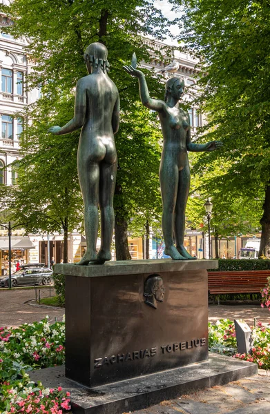 フィンランドのヘルシンキ2022年7月19日 ヴィトンの店舗の向かいにザカリアス トペリウスへの事実と運命の記念碑として知られている公園の黒の台座の上に女性の緑がかったブロンズ二重像 — ストック写真