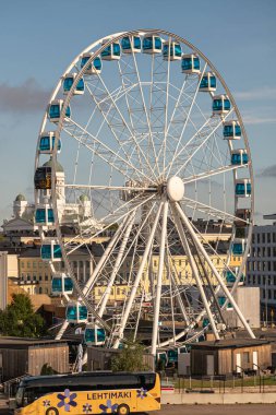 Helsinki, Finlandiya - 19 Temmuz 2022: Skywheel limanda ve Katedral arkada görünüyor. Önde sarı tur otobüsü, arkada mavi gökyüzünün altında şehir manzarası