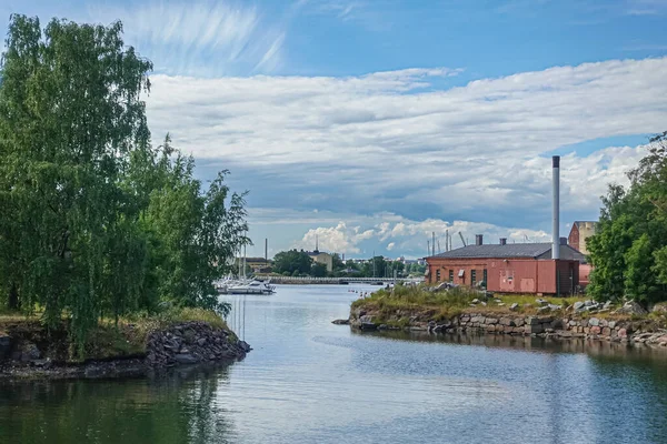 フィンランドのヘルシンキ 2022年7月19日 スオメリンナ要塞 青い雲の下でビジネスや海岸線の緑の葉とゲストポートでヨットを示す2つの島の間の海のリンクに沿って風景 — ストック写真