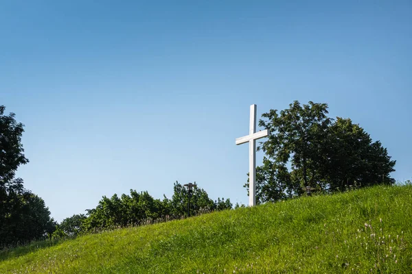爱沙尼亚 2022年7月21日 蓝天下绿色草坪山上的白色十字架 附近的深绿色树叶 — 图库照片