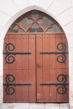 Estonya, Tallinn - 21 Temmuz 2022: Brown tarzı kapı kapı dolaşma, parmaklıklar arasında çerçevelenmiş. Pikk 62 'de heykeltraş edilmiş siyah metal kapı menteşeleri var.