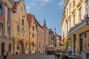 Estonya, Tallinn - 21 Temmuz 2022: Pikk caddesi boyunca 35 numaradan güneye bakıyoruz. Çiçekler, elbiseler ve bayraklar renk ekler