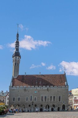 Estonya, Tallinn - 21 Temmuz 2022: Gotik belediye binasının kapanışı, Raekoda, adını aldığı kareye mavi bulutlar altında hakim. 