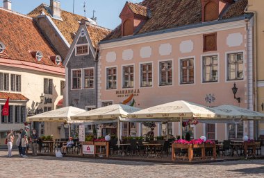 Estonya, Tallinn - 21 Temmuz 2022: NE Town Hall Meydanı 'nın mimarisi ve Hint restoranı Maharaja ve diğer binalar. Kırmızı çatı, çiçek bayrakları ve kıyafet renk katar