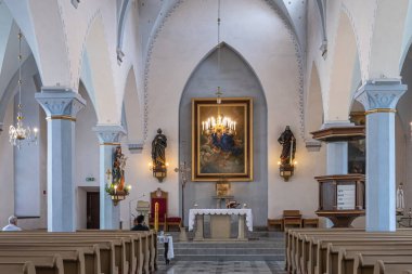 Estonya, Tallinn - 21 Temmuz 2022: St. Peter ve St. Paul Katedrali içinde. Heykeller, kürsü, sunak ve kısmen ışıklı avizenin arkasında ressamlar. Nave 'deki banklardaki insanlar