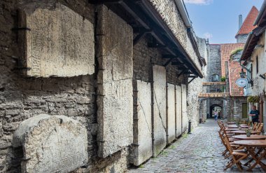 Estonya, Tallinn - 21 Temmuz 2022: Tarihi ve yıkık St. Catharine Dominik Manastırı Kilisesi. Sokakta sergilenen büyük antik çimento gri stel koleksiyonu. Controvento Barı