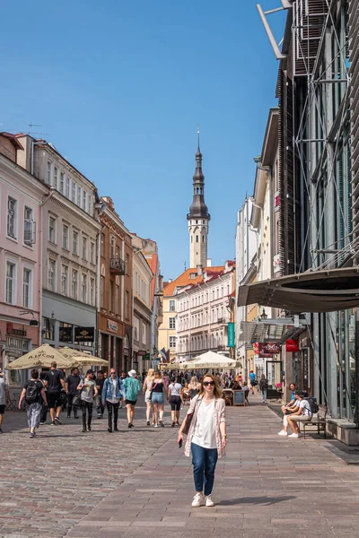 stock image Estonia, Tallinn - July 21, 2022: Looking west on Viru Tanav shopping street to Town Hall tower against blue sky. Many pedestrians and business facades on both sides