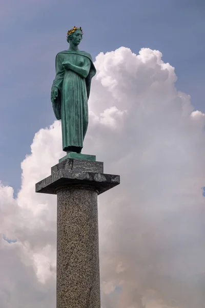 コペンハーゲン デンマーク 2022年7月23日 背の高い大理石の列に緑のブロンズ像の閉鎖青の雲の風景に対して アンデルセン大通りに黄金の冠を持つ女性を備えています — ストック写真