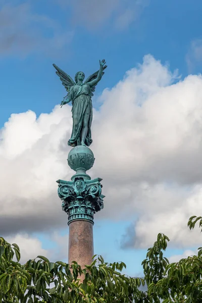 丹麦哥本哈根 2022年7月24日 Ivar Huitfeldt专栏 蓝云下 兰吉尼公园海军上将棕色石柱顶部青铜绿色维多利亚雕像 — 图库照片
