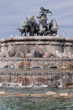 Kopenhag, Danimarka - 24 Temmuz 2022: Gefion Çeşmesi 'nin tepesinde gri-mavi gökyüzüne karşı öküz ve İskandinav tanrıçası Gefjon' un yer aldığı büyük bronz heykel kompozisyonu. Şelale Şelaleleri