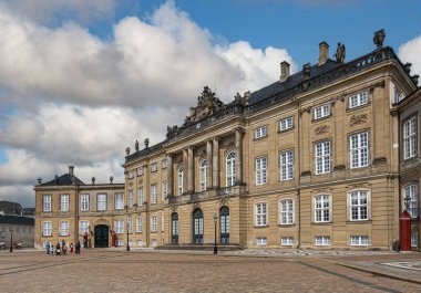 Kopenhag, Danimarka - 24 Temmuz 2022: Amalienborg 'daki Kahverengi Taş Frederik Sarayı. Pediment heykelleri, sütunları ve klasik mimarisi olan kahverengi taşlar.