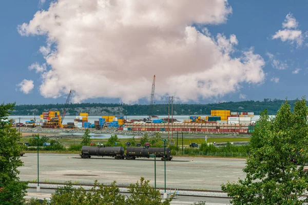 美国阿拉斯加州安克雷奇 2011年7月23日 2辆黑色坦克车厢 在蓝天浓密的白云下背靠著集装箱堆栈 绿叶及海港景观 — 图库照片