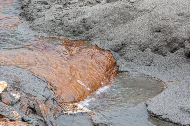 Denali Park, Alaska, ABD - 24 Temmuz 2011: Nenana Nehri. Gri su birikintisi turuncu kırmızı kayanın dibinde, suyun hızla aktığı yerde, hepsi kenarlarında gri öğütülmüş kayalar halinde. 