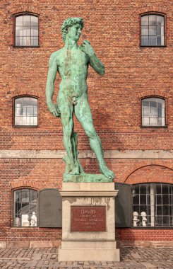 Kopenhag, Danimarka - 13 Eylül 2010: Michelangelo David yeşil bronz heykeli kırmızı tuğla tarihi depo cephesine tamamen yakın plan