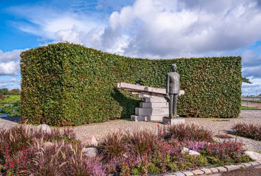Kopenhag, Danimarka - 13 Eylül 2010: Danimarka Kralı 9. Frederik 'in bronz heykeli, çimento kirişleri ve yeşil yapraklar Langelinie parken, pembe ve kırmızı çiçekler