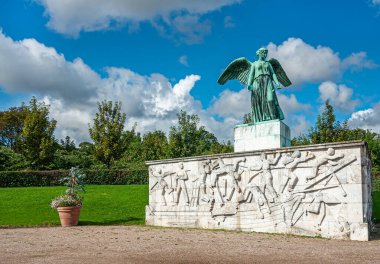 Kopenhag, Danimarka - 13 Eylül 2010: Beyaz taş heykelin üzerinden bakan yeşil melek heykeli mavi bulutların altındaki yeşil Langelinie bahçesinin Barış Heykeli