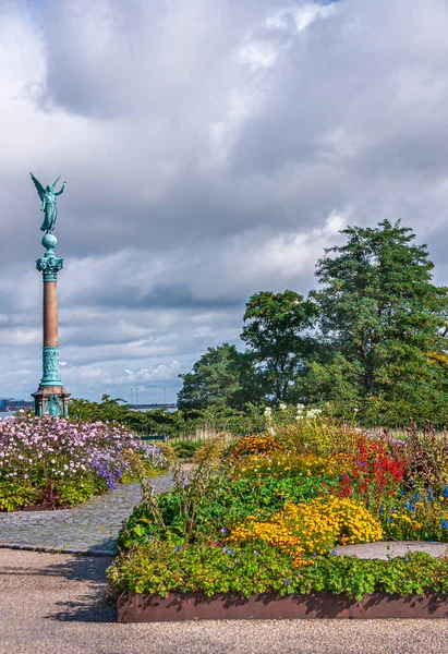丹麦哥本哈根 2010年9月13日 海军上将Ivar Huitfeldt在蓝色云彩下 面对着各种颜色的花朵 棕柱上青铜神胜利雕像 — 图库照片