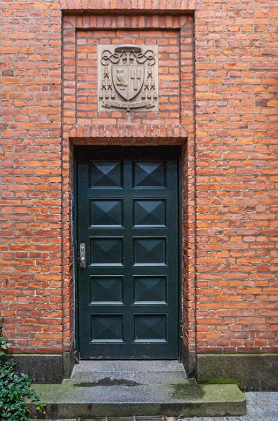 コペンハーゲン デンマーク 2010年9月13日 赤レンガの壁に設定されているカトリック教会 サンクト アンガーズ キルケのサイドドアの上に閉鎖 パケム ヴェリテムの紋章 — ストック写真