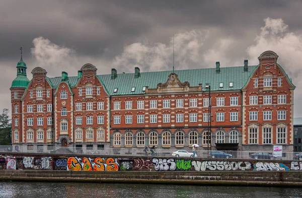 丹麦哥本哈根 2010年9月14日 铁根红色的石头和白色的框框窗户在灰色的雨景下 穿过运河 街上涂鸦和汽车 — 图库照片