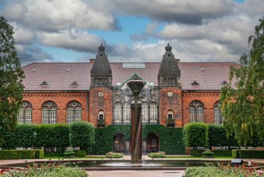 Kopenhag, Danimarka - 14 Eylül 2010: Kraliyet Kütüphanesi yeşil bahçesi, fıskiyeli havuz, kırmızı tuğlalı Yahudi müzesi önünde mavi bulutların altında..