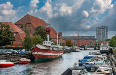 Kopenhag, Danimarka - 14 Eylül 2010: Frederiksholms Kanalı 'na tarihi kırmızı-beyaz deniz feneri teknesi yanaştı. Ofis ve çevredeki konut binaları. Küçük tekneler ve mavi bulutlar