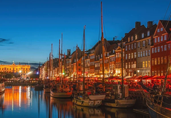 stock image Copenhagen, Denmark - September 13, 2010: Night view. Line of iconic Nyhavn restaurant facades in bright colors under night sky. Kongens Nyhavn at end, Boats on canal water